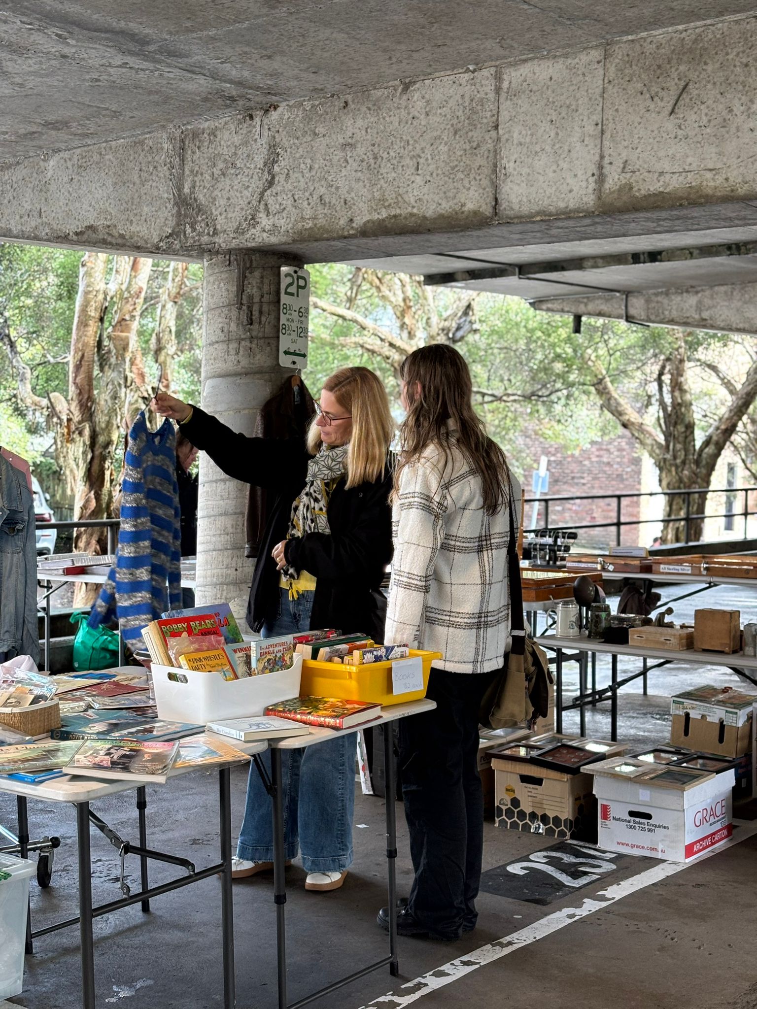Two women at the Gordon Markets looking at clothes.